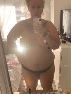 Woman taking a selfie in her bedroom mirror.