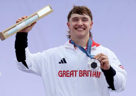British BMX cyclist Kieran Darren David Reilly holding his silver medal and certificate at the Paris 2024 Olympics.