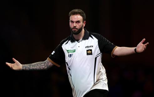 Ross Smith reacting during a darts match.
