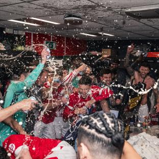 Wrexham AFC players celebrating with champagne.