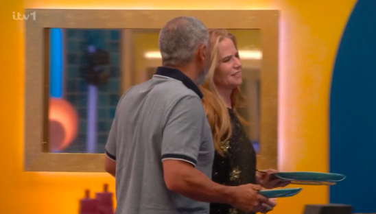 Screenshot of a man and woman holding plates.