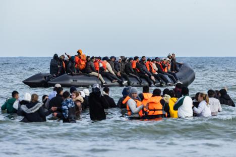 Migrants board a smuggler's boat to cross the English Channel.