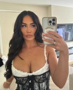 Woman taking a selfie in a lace corset.