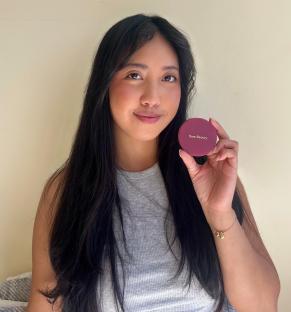 Woman holding a Rare Beauty compact.
