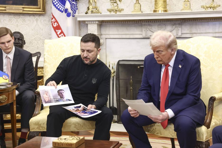 Volodymyr Zelenskyy and Donald Trump in the Oval Office reviewing documents and photos.