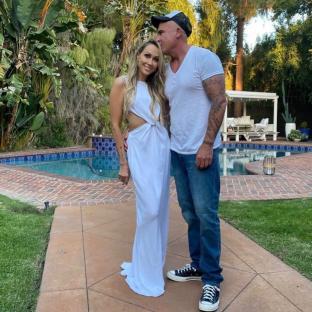Tish Cyrus and Dominic Purcell by a pool.