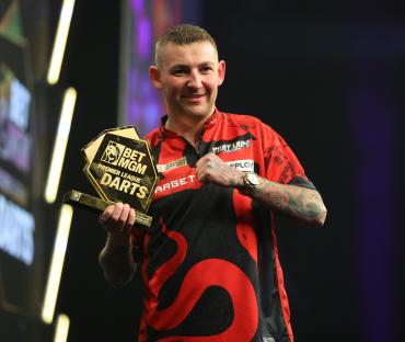 Nathan Aspinall holding Premier League Darts trophy.