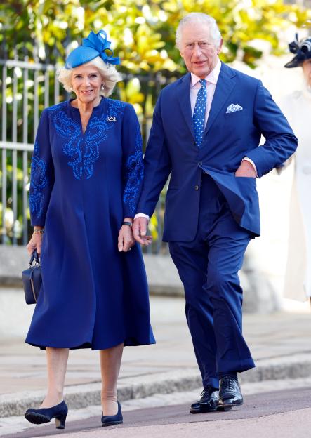 King Charles III and Camilla, Queen Consort, holding hands and walking.